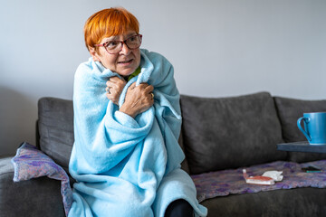 Senior woman feeling cold at home with home heating trouble