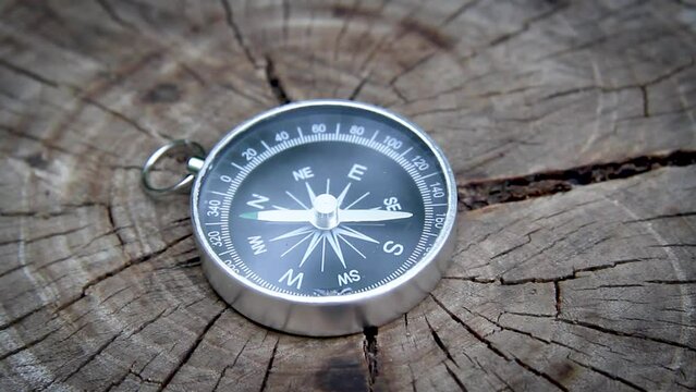 Search for the cardinal points with a compass. Compass in hand. A man got lost in the woods.Exit from the forest on a compass.