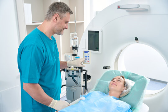 Doctor in diagnostic center prepares patient for the tomography procedure