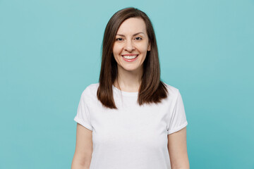 Obraz premium Young smiling happy fun cool cheerful woman 20s she wear blank print design white t-shirt looking camera isolated on plain pastel light blue cyan background studio portrait. People lifestyle concept.