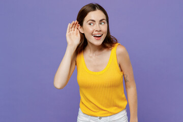 Young curious nosy smiling woman 20s she wear yellow tank shirt try to hear you overhear listening...
