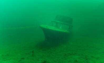 Gloomy underwater wreck of recreational speed boat