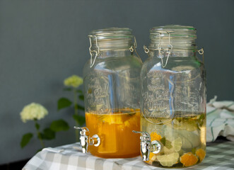 Natural fruit content refreshment cold drinks in glass containers outdoor, on tabletop.