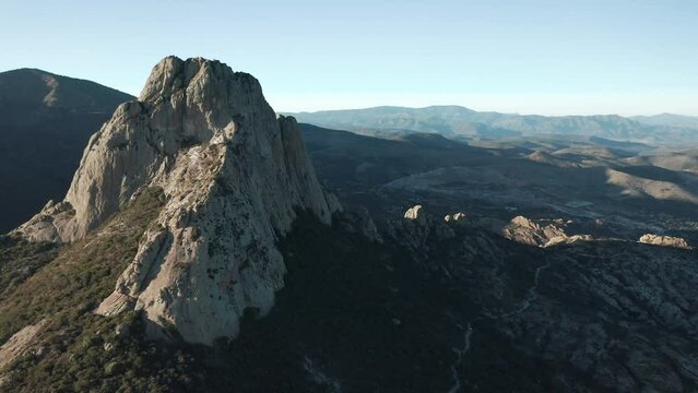 Aerial view of Pena de Bernal mountain with canyon rocky hills at sunset in Mexico