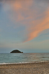 Naklejka na ściany i meble Scenic view at sunset of Gallinara isle from the beach