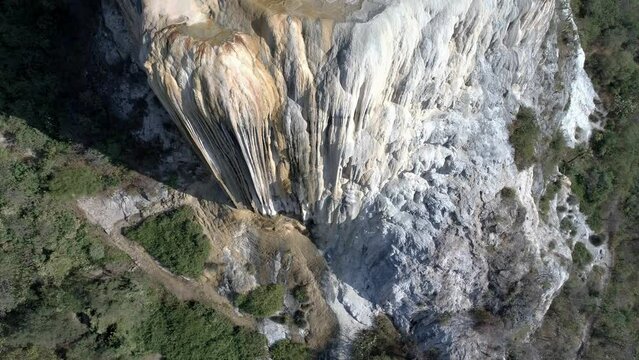 Drone view over a rocky cliff Hierve el Agua with forest mountains in Mexico