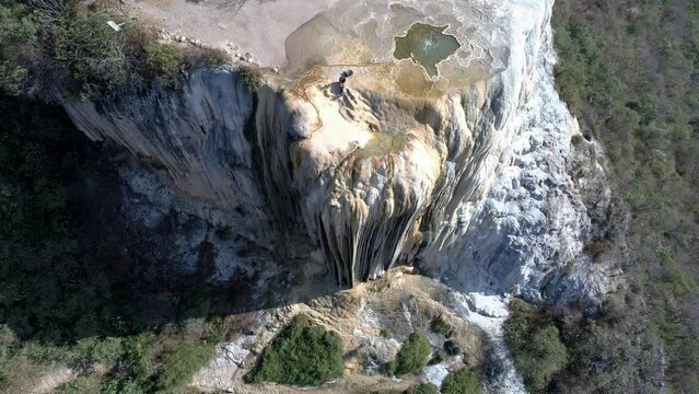 Drone beautiful view of Hierve el Agua rocky cliff with forest mountains in Mexico