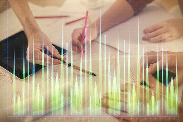 Double exposure of forex graph drawing and man and woman working together holding and using a mobile device. Trade concept.