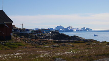 Greenlandic buildings at iceberg shore during summer in Ilulissat