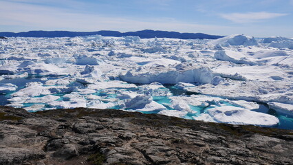 Icebergs in turquoise water close to coast at Ilulissat, Greenland