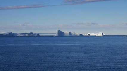Panoramic view of icebergs at calm sea during cruise in Greenland