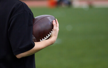 Man hold ball for american football in his hand.
