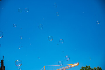 Soap Bubbles In Focus Against A Blue Sky In Barcelona, Spain. Copy Space.