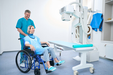 Woman in wheelchair and radiologist in x-ray room