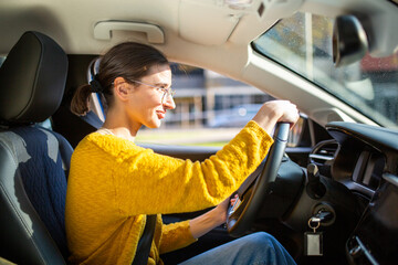 Attractive young caucasian woman driving car