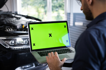 Car service mechanic uses laptop computer with green screen mock up chroma key car diagnostic software. Car Scanner Computer Diagnostics. Automotive Electronic Diagnostic - Powered by Adobe