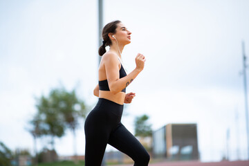 Fitness woman wearing earphones doing running workout outside