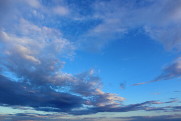 Background of azure sky with blue clouds on a summer sunny day.