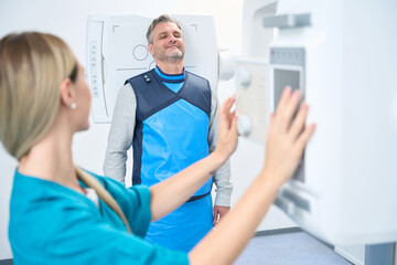 Obraz premium Doctor adjusts the head x-ray machine in clinic