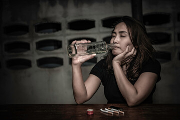 Fototapeta na wymiar Asian woman drink vodka alone at home on night time,Thailand people,Stress woman drunk concept