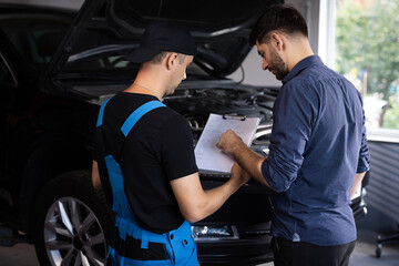 Manager Checks Data on a Tablet Computer and Explains the Breakdown to Mechanic. Car Service...