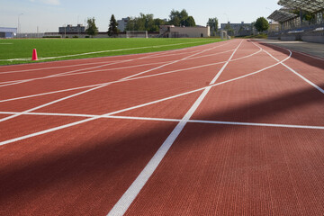 Running track. Red treadmill at the stadium with white lines.