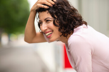 Happy woman looking away with her hand in hair