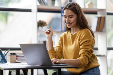 Business asian woman working on laptop computer managing her business in workplace, doing calculator planning document analyzing the financial report, business plan investment, finance analysis. 