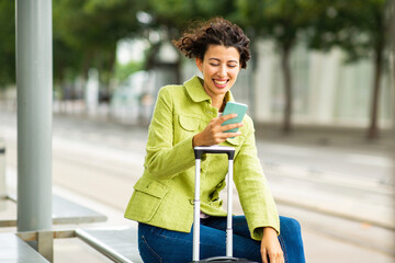 Female traveler using mobile phone at bus stop