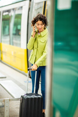 Woman talking on mobile phone while waiting at bus stop