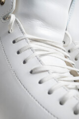 A pair of women's figure skates on a white background, emphasis on laces.