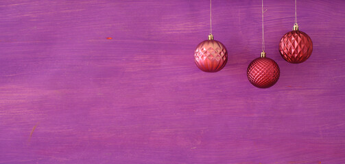 Christmas balls on purple background.Christmas template with large copy space.Negative space technique.