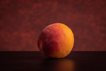 Fresh apricots on black table with red background