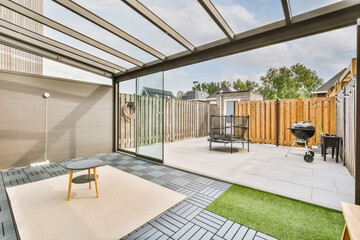 Neat paved patio with sitting area and small garden near wooden fence