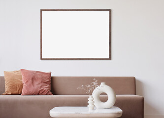 Blank frame mockup in modern interior design with trendy vase and sofa on empty white wall background, Horizontal template for paintings, photo or poster. Artwork mock-up