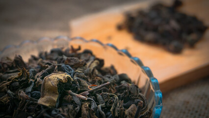 Dried roasted green tea leaves on the bowl on burlap background, Japanese tea, Houji tea