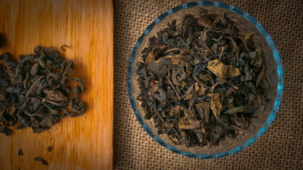 Dried roasted green tea leaves on the bowl on burlap background, Japanese tea, Houji tea