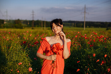 a beautiful girl in a beautiful red dress with a bouquet of red poppies, in a field, on a summer day