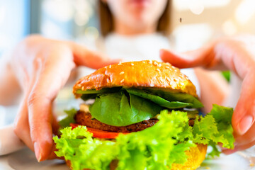 Vegan burger healthy vegetarian hamburger. Salad, avocado, vegetable on veggie sandwich eating cute...