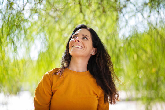 Cheerful woman admiring view at park
