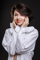 beautiful girl in a white men's shirt, on a black background in the studio