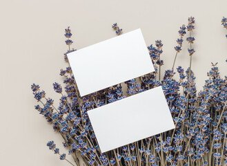 Paper business cards on lavender flowers top view, flat lay. Blank mockup paper cards for business,...