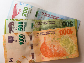 Billetes de pesos argentinos de mas alta denominacion, billetes de 1000, 500 y 200 pesos argentinos sobre fondo blanco - obrazy, fototapety, plakaty
