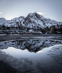 Snowy mountain reflections in a parking lot of a ski resort near lake Tahoe, California