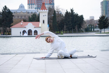 Young beautiful athlete doing exercises at the park