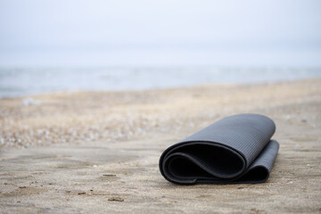 Photo of rolled yoga mat at the beach