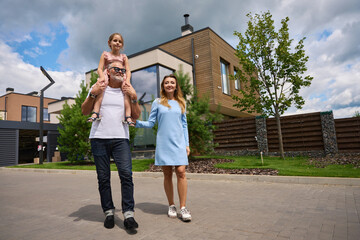 Photo of happy family on background of cottage and pines