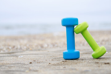 Two dumbbell on the ground at the beach