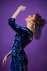 Vertical photo of a young lady dancing on purple background