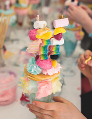 Over shake and freak shake, process of cooking extreme colorful milkshakes on a kids birthday party celebration, catering banquet table with candy sweets desserts, monster shakes